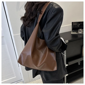 Nahaufnahme einer großen braunen Tote Bag aus weichem PU-Leder, getragen von einem Modell