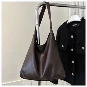 Detail einer großen dunkelbraunen Tote-Bag aus Leder, hängend an einem Kleiderbügel