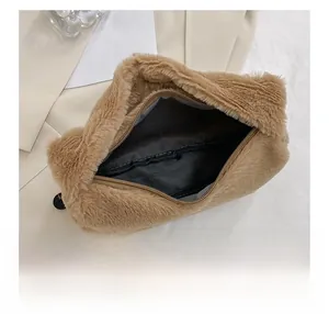 Detailweergave van de ritssluiting en donkere stoffen binnenkant van deze bruine pluche handtas