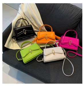 Detail view of colorful crossbody bags in black orange pink green and white with gold locks