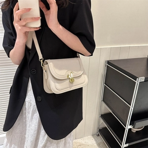 Cream vintage crossbody bag with a golden rabbit-shaped twist lock and adjustable strap