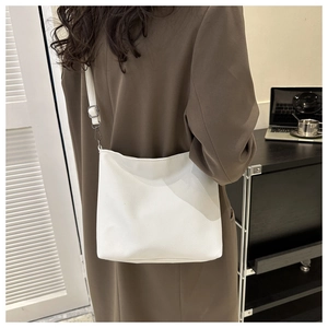 Detail of white lychee-patterned shoulder bag showing the adjustable strap on a person