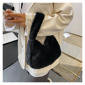 Detail van zwarte handtas van kunstbont met zachte textuur gecombineerd met blazer