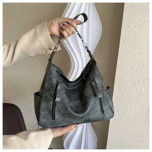Detail of dark gray vintage leather shoulder bag with functional vertical zippers