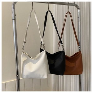 Three minimalist soft leather hobo bags in white, black and brown with adjustable straps