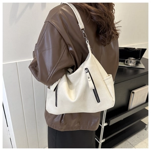 Detail of creamy white PU leather tote bag showing soft texture and vertical metal zippers