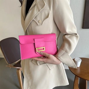 Fashionable bright pink envelope clutch bag with gold metal buckle held by model