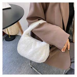 Detailopname van witte pluche schoudertas op bruine blazer, toont zachte imitatiebont-textuur