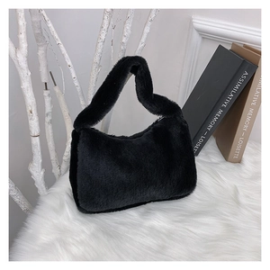 Detail van zwarte faux fur handtas met zachte pluche textuur op witte achtergrond