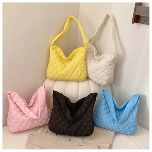 Detalle de bolsos acolchados tipo tote en colores amarillo, blanco, rosa, negro y azul