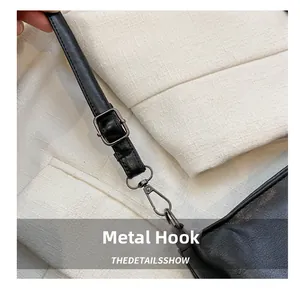 Détail de la bandoulière en cuir noir avec boucle et crochet métalliques gris foncé