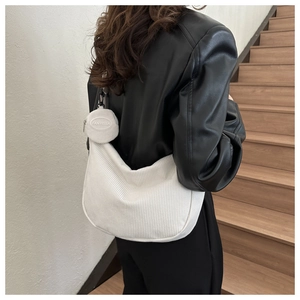 Détail du sac bandoulière en velours côtelé blanc avec un mini porte-monnaie rond