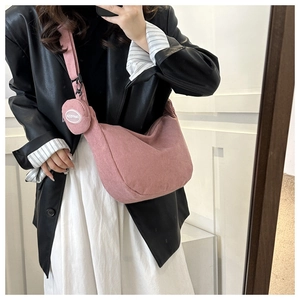Détail du sac bandoulière en velours côtelé rose avec mini pochette ronde zippée