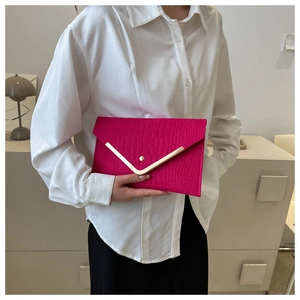 Detail of rose red envelope clutch featuring faux crocodile texture and golden V-shaped trim