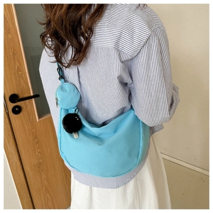Light blue nylon crescent crossbody bag with small pouch shown on model