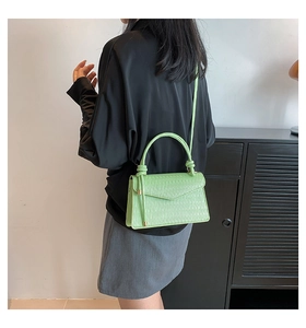 Detail of light green pleated leather bag showing the textured surface and handle
