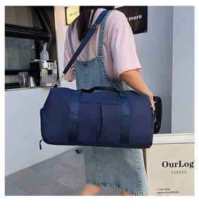 Detail of navy blue nylon travel bag with adjustable strap in a minimalist cafe setting
