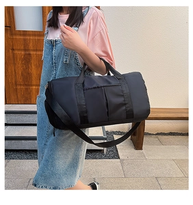 Black waterproof yoga bag with adjustable straps shown in an outdoor lifestyle setting