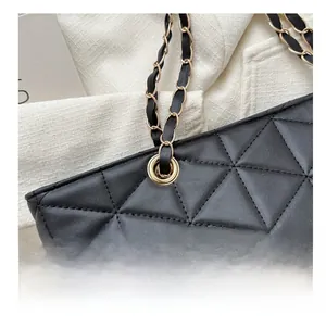 Close-up of black quilted tote bag with gold hardware and chain strap details
