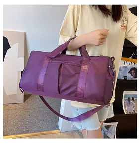 Detail view of purple gym bag featuring thick handles and adjustable shoulder strap