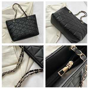 Close-up of quilted tote bag with metal zipper and woven chain strap detail