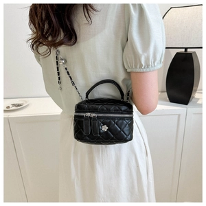 Vue arrière d'un mini sac seau matelassé noir avec bandoulière chaîne et fleur en métal
