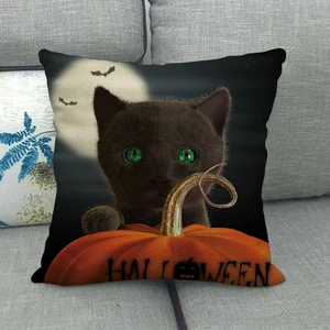 Housse de coussin Halloween avec chat noir et citrouille sur un canapé gris
