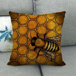 Linen pillowcase with honeybee and honeycomb pattern on a gray fabric sofa