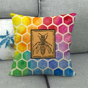 Rainbow honeycomb linen pillowcase with detailed wasp illustration on a gray sofa