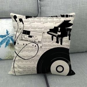 Moderner Kissenbezug mit Klavier und Schallplatten Motiv auf einem grauen Sofa