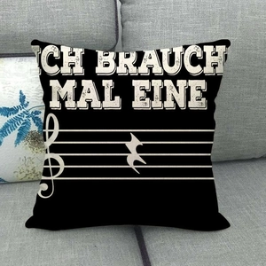 Schwarzer Kissenbezug aus Leinen mit Noten und deutschem Text auf modernem grauem Sofa