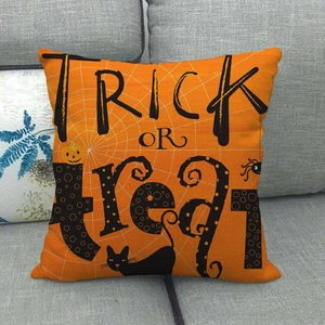 Detail of Halloween linen pillowcase with Trick or Treat print on a grey sofa