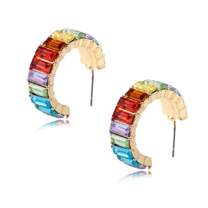 Detailed view of C-shaped earrings with colorful zircon stones on gold metal base