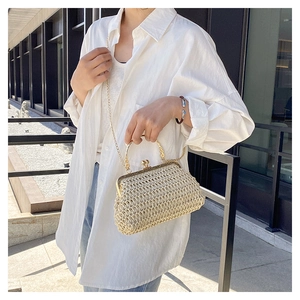 Détail du sac en paille tressée avec poignées dorées et fermoir vintage chic