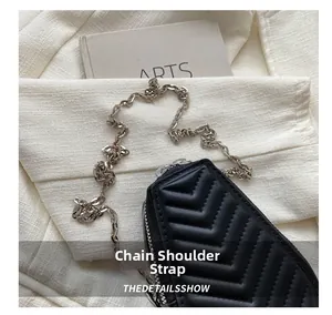 Close-up of V-shaped quilted black matte leather with elegant silver chain strap