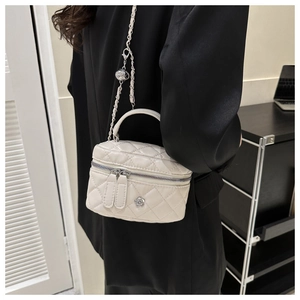 Détail du mini sac seau blanc matelassé avec fleur argentée et bandoulière chaîne