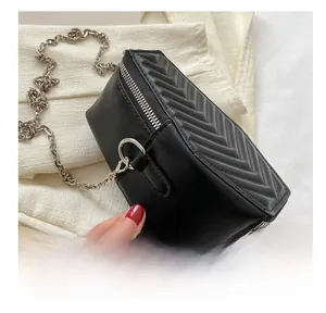 Detailed close-up of V-shaped quilted black leather texture and silver chain strap hook