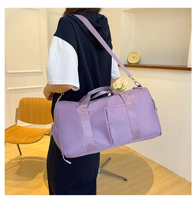Rear view of model holding a purple large-capacity yoga bag with detachable shoulder strap