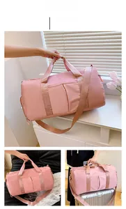 Detailed view of pink waterproof nylon travel duffel bag with shoulder strap and luggage strap