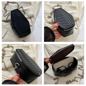 Detail of black coffin-shaped crossbody bag with V-quilted back and silver chain