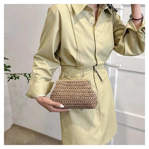 Détail du sac à main vintage en paille avec cadre doré et bandoulière sur robe vert clair
