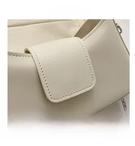 Detail of beige faux leather shoulder bag with fine texture and silver chain strap