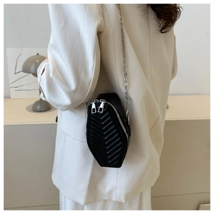 Macro shot of black hexagon crossbody bag with V-quilted faux leather and silver chain strap