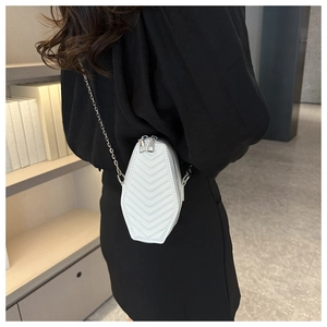 Detailed side view of white hexagonal coffin crossbody bag with V-quilted faux leather