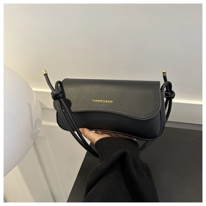 Close-up of minimalist black square bag featuring gold Fashion & Bags lettering