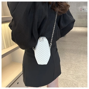 Detailed back view of a white quilted hexagonal mini chain crossbody bag on a model