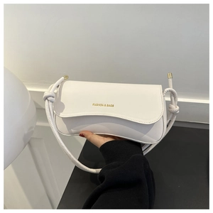 Detail of white rectangle shoulder bag with knotted rope strap and gold fashion logo
