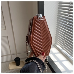 Detail of a dark brown coffin-shaped crossbody bag with V-quilted faux leather and chain
