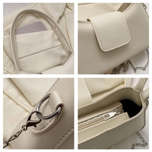 Detail of cream faux leather handbag showing silver chain strap and stitching