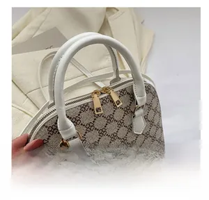 Close-up of shell-shaped handbag showing floral print and golden metal zipper detail